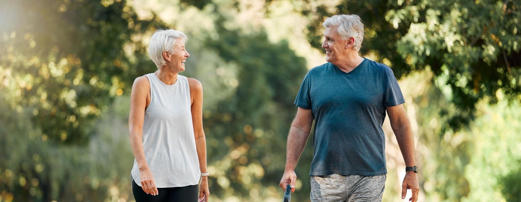 a man and a woman walking a dog on a leash