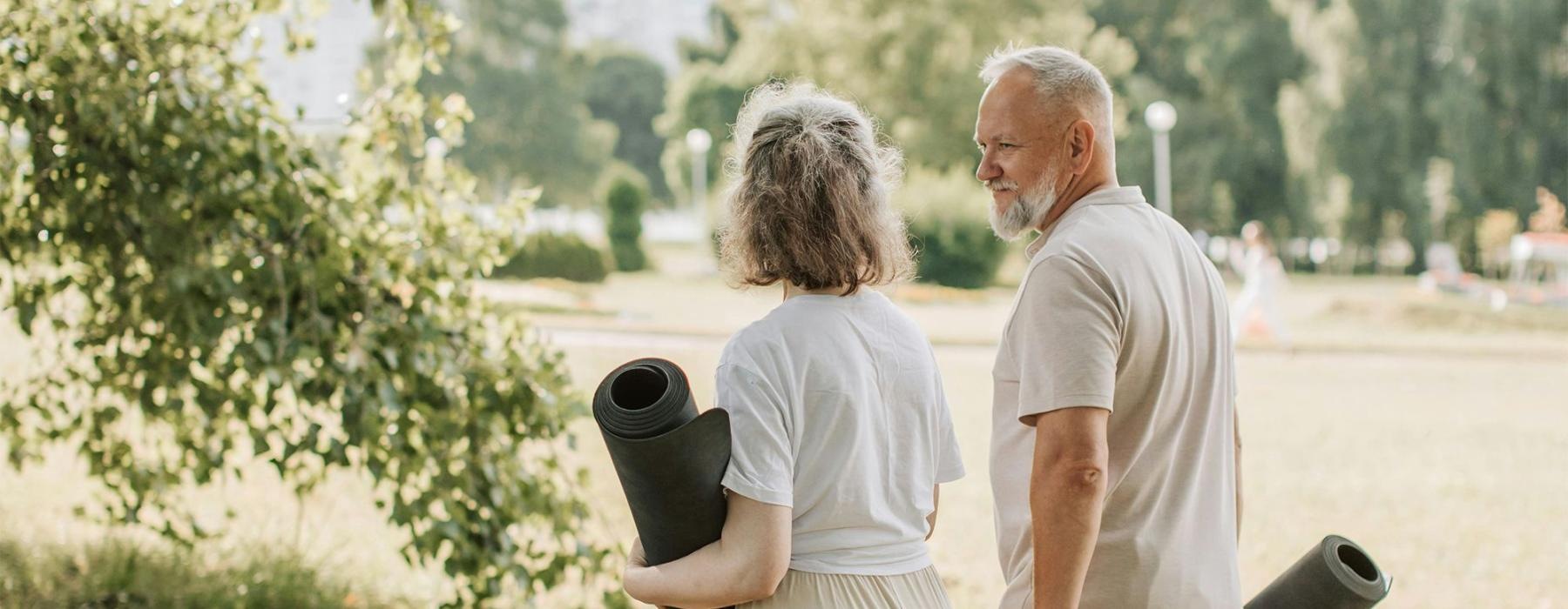 a man and woman walking with yoga mats